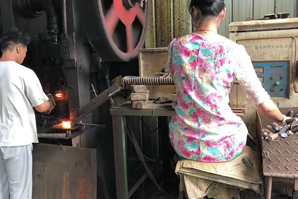 螺纹钢筋通过超音频感应加热设备加热后冲床锻压成螺母坯型